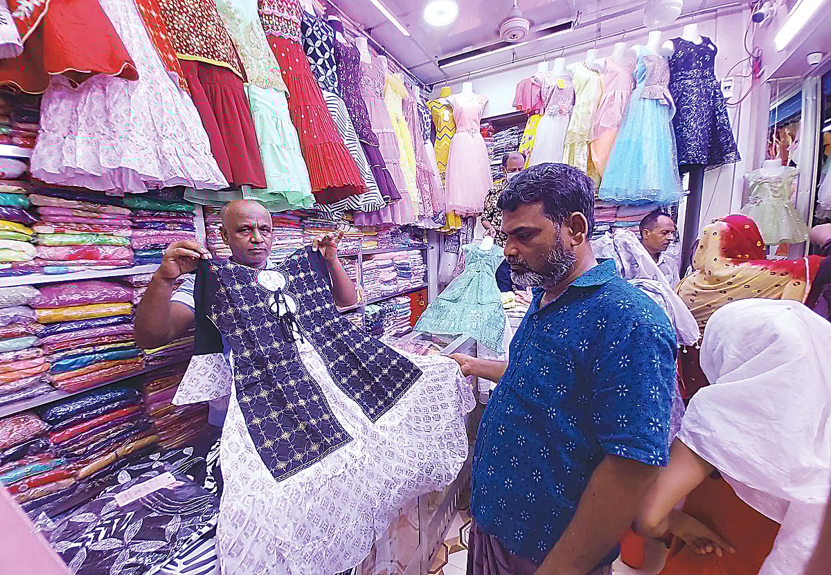 ছোটদের পোশাক দেখছেন ক্রেতারা। রাজশাহী আরডিএ মার্কেটে গতকাল বৃহস্পতিবার