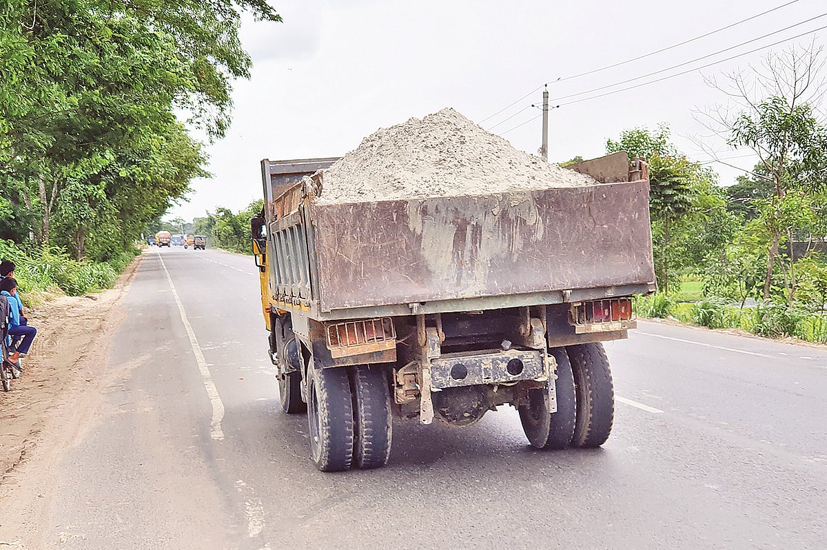 খোলা ট্রাকে বালু-মাটি বহন করায় মানুষের চোখমুখে বালু-ধূলিকণা ঢুকে স্বাস্থ্যঝুঁকি তৈরি হচ্ছে। গত বুধবার ঢাকা-খুলনা মহাসড়কের গোয়ালন্দ ফিড মিল এলাকায়