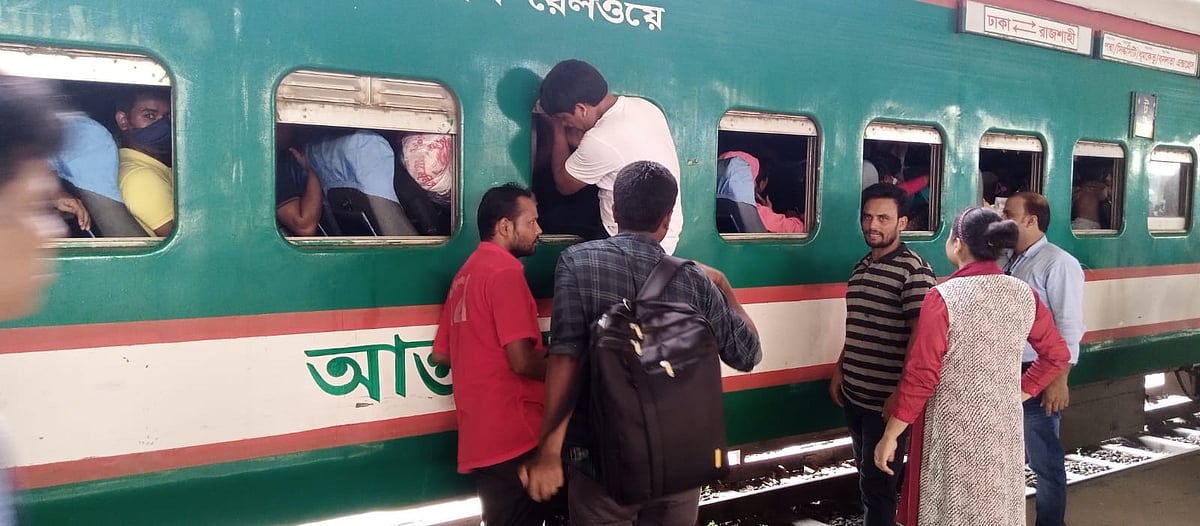 রাজশাহীগামী ধুমকেতু এক্সপ্রেস ট্রেনের জানলা দিয়ে উঠছেন যাত্রীরা