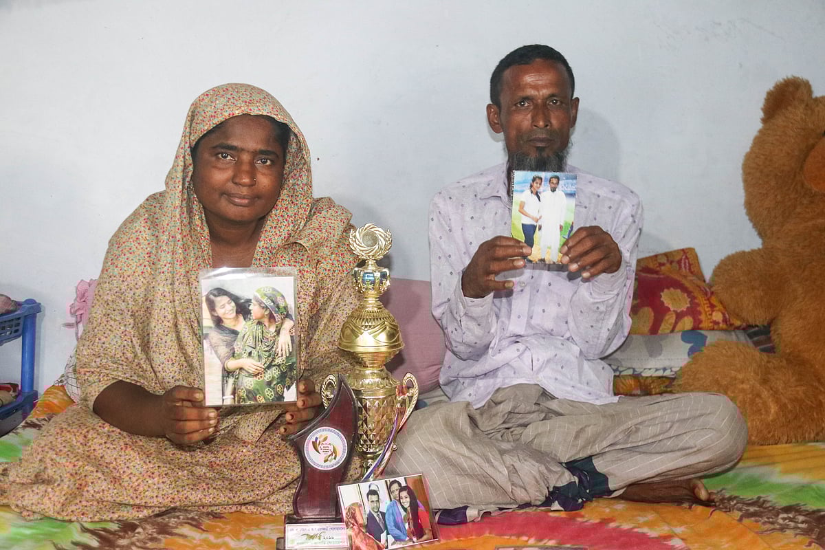 মাসুরা পারভীনের ছবি ও বিভিন্ন পুরস্কার হাতে নিয়ে বাবা রজব আলী ও মা ফাতেমা বেগম। সোমবার সাতক্ষীরা শহরের বিনেরপোতা এলাকায় তাঁদের বাড়িতে