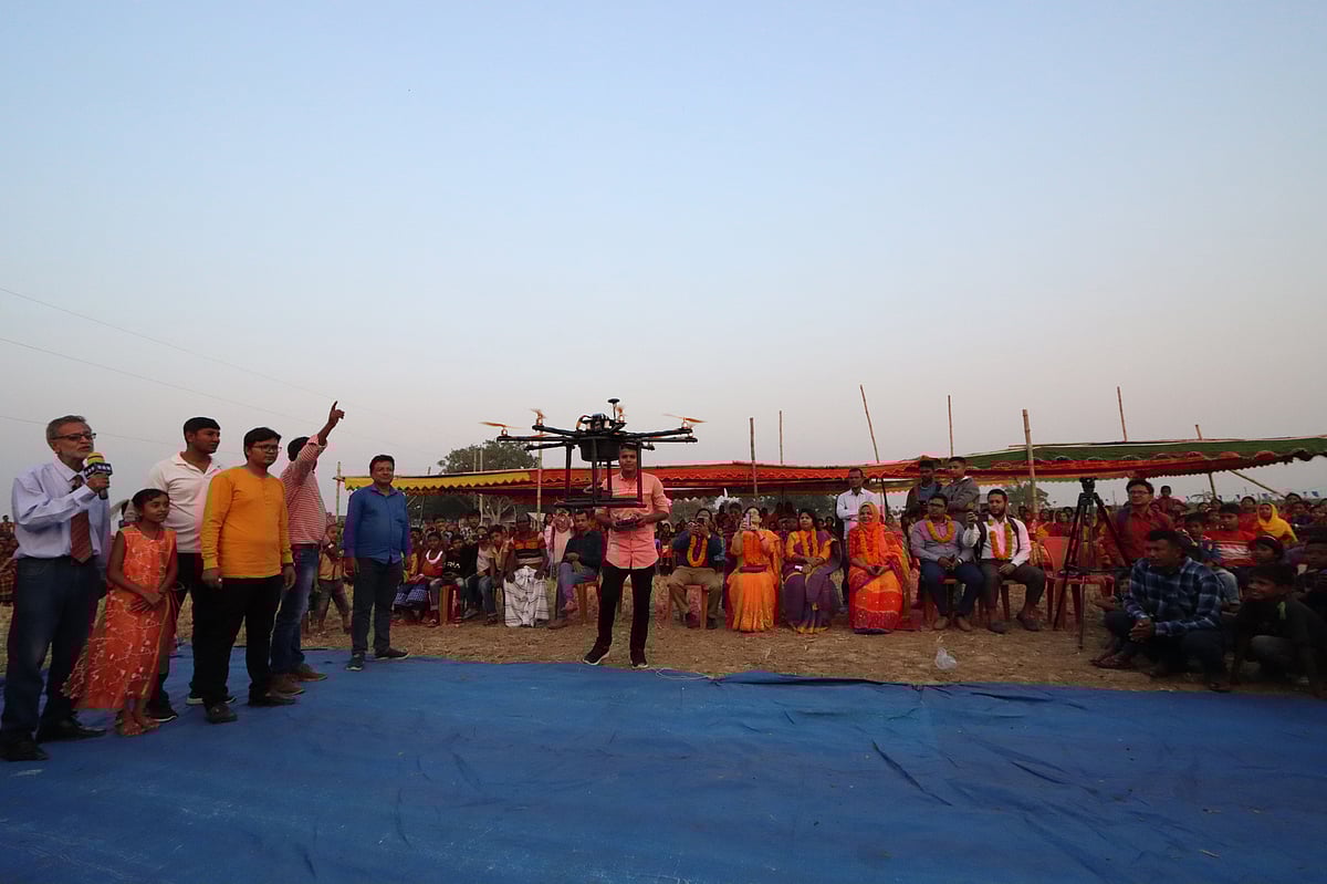 জমিতে কীটনাশক ছিটানোর ড্রোন উড়িয়ে দেখাচ্ছেন এর উদ্ভাবক সবুজ সরদার। বুধবার বিকেলে রাজশাহীর গোদাগাড়ী উপজেলার চৈতন্যপুর গ্রামে নবান্ন উৎসবে