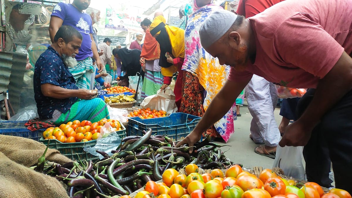 কৃষকের সঙ্গে দরদাম করে সবজি কিনছেন ক্রেতারা। শুক্রবার ভোরে
মুন্সিগঞ্জ শহরের সকালের বাজারে