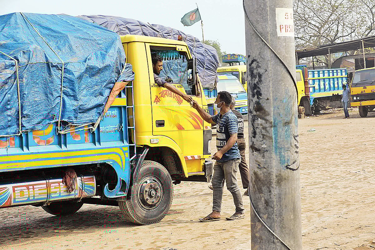 ট্রাকচালকের কাছ থেকে টাকা নিচ্ছেন আদায়কারী এক শ্রমিক। গত বুধবার বেলা আড়াইটার দিকে বগুড়া শহরের ভবেরবাজারে
