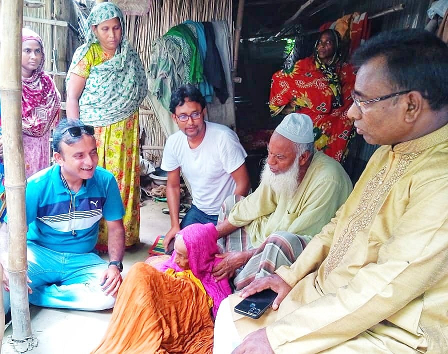 মায়ের কাঁধে হাত রেখে পেছনে বসেছেন মোতালেব হোসেন। মঙ্গলবার পাবনার চাটমোহর উপজেলার ছাইকোলা ইউনিয়নের চর এনায়েতপুর গ্রামে