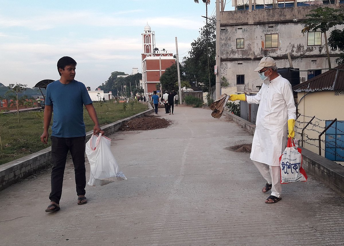 ময়লা কুড়াচ্ছেন অবসরপ্রাপ্ত কলেজশিক্ষক মো. আব্দুল খালিক (ডানে)। ২০ নভেম্বর বিকেলে মৌলভীবাজারে মনু নদের পাড়ে শান্তিবাগ ওয়াকওয়েতে