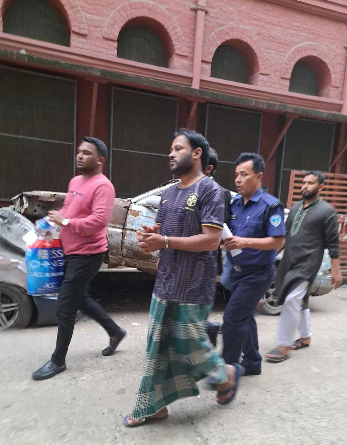 ছাত্রদল নেতা ভাইকে না পেয়ে গ্রেপ্তার করে নিয়ে যাওয়া হচ্ছে ক্রীড়াবিদ কাজী নাজিম উদ্দিনকে। আজ সকালে চট্টগ্রাম আদালত প্রাঙ্গণে