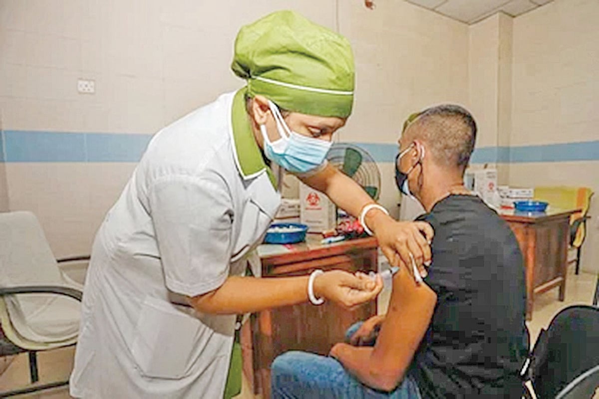 করোনার টিকা দিচ্ছেন এক স্বাস্থ্যসেবাকর্মী