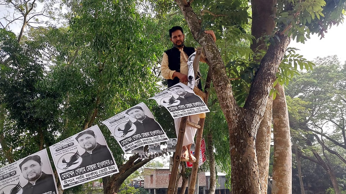 শরীয়তপুর-১ আসনের স্বতন্ত্র প্রার্থী গোলাম মোস্তফা একাই নির্বাচনী প্রচারণা চালাচ্ছেন। নিজেই মই দিয়ে গাছে উঠে পোস্টার ঝোলাচ্ছেন। গতকাল বৃহস্পতিবার সদরের সুবচনি এলাকায়