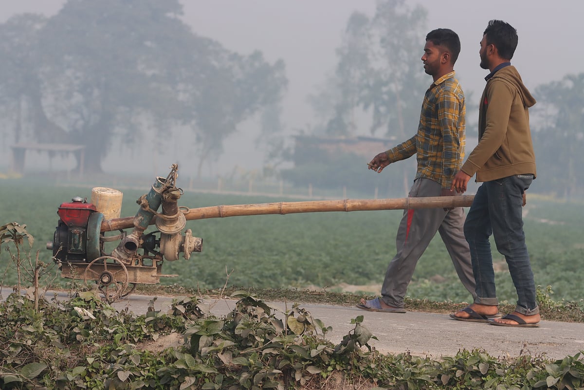 শীতের সকালে বোরো খেতে পানি দিতে সেচের মেশিন ঠেলে নিয়ে যাচ্ছেন যুবক। ছবিটি রংপুর শহরতলির বুড়াইল এলাকা থেকে তোলা। ৯ ফেব্রুয়ারি