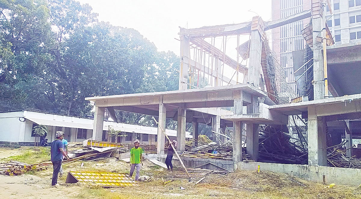 রাজশাহী বিশ্ববিদ্যালয়ে নির্মাণাধীন শহীদ এ এইচ এম কামারুজ্জামান ভবনের ধসে পড়া সাটারিং সরিয়ে নিচ্ছেন শ্রমিকেরা। গতকাল বেলা সাড়ে ১১টায়