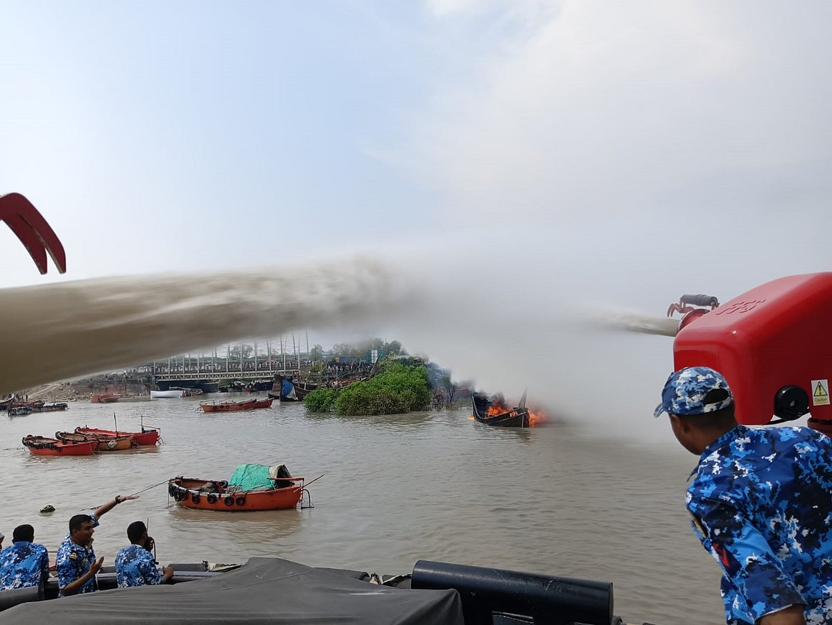 চট্টগ্রামের পতেঙ্গায় মাছ ধরার নৌকার আগুন নিয়ন্ত্রণের চেষ্টা করছেন কোস্টগার্ডের সদস্যরা। গতকাল দুপুরে