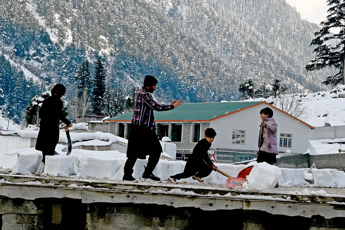 পাকিস্তানের একটি এলাকায় জমা তুষার সরাচ্ছে শিশুরা