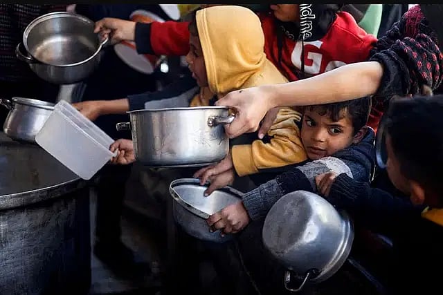 ফিলিস্তিনের গাজা উপত্যকার রাফা শহরে ত্রাণের অপেক্ষায় থাকা শিশুরা