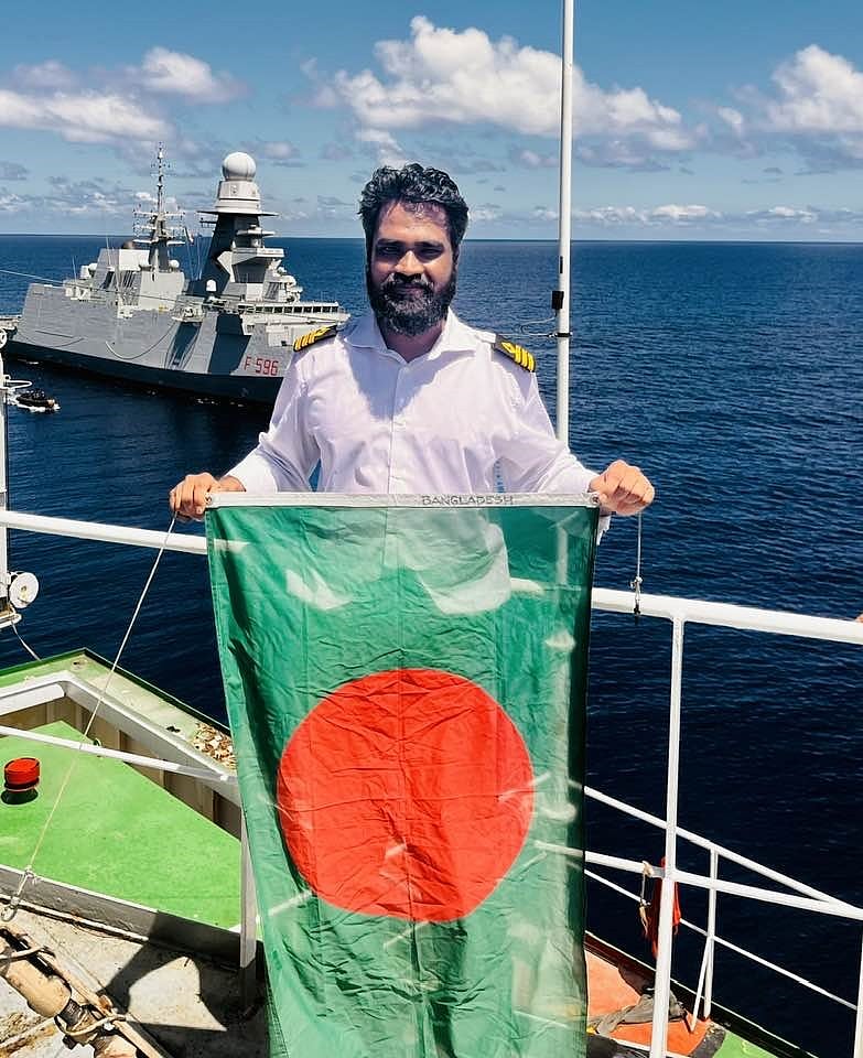 লাল-সবুজের পতাকা হাতে এমভি আবদুল্লাহ জাহাজের প্রধান কর্মকর্তা আতিক উল্লাহ খান।