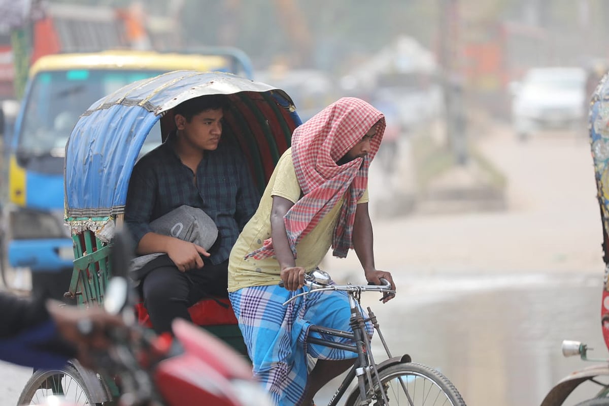 রোদ থেকে কিছুটা স্বস্তি পেতে রিকশার যাত্রী হুট তুলে দিয়েছেন। আর রিকশাচালক গামছা দিয়ে মাথা ঢেকেছেন। মুগদা হাসপাতালের সামনের সড়ক। ঢাকা, ২৩ এপ্রিল