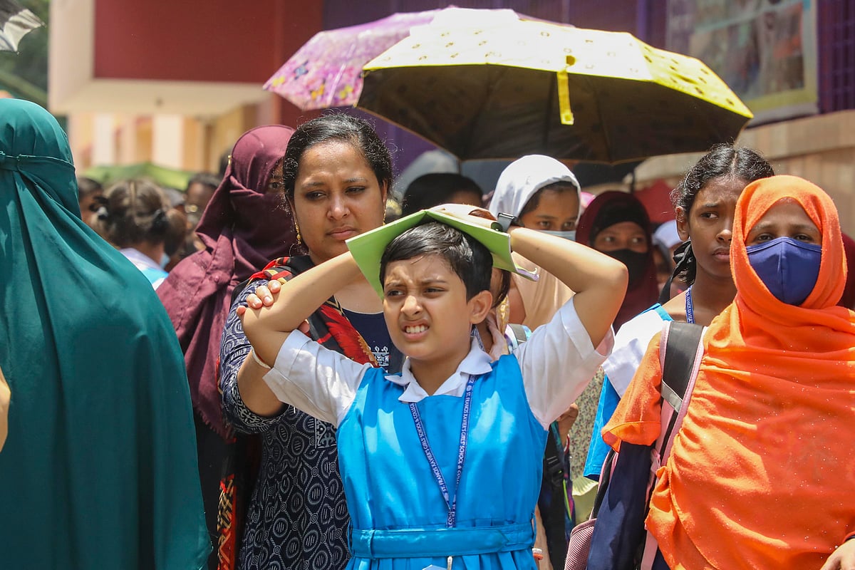 বেলা সাড়ে ১১টায় স্কুল ছুটির পর রোদ থেকে নিজেকে রক্ষায় মাথায় হাত দিয়েছেন এই শিক্ষার্থী। রোববার, লক্ষ্মীবাজার, ঢাকা