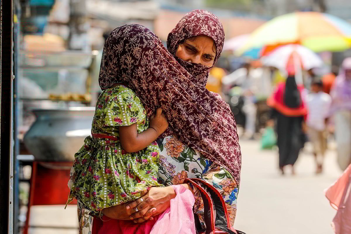 খরতাপে রোদ থেকে শিশুসন্তানকে বাঁচাতে নিজের ওড়না দিয়ে তাকে ঢেকে রেখেছেন মা। সোনাডাঙ্গা বৌবাজার, খুলনা শহর, ২৬ এপ্রিল