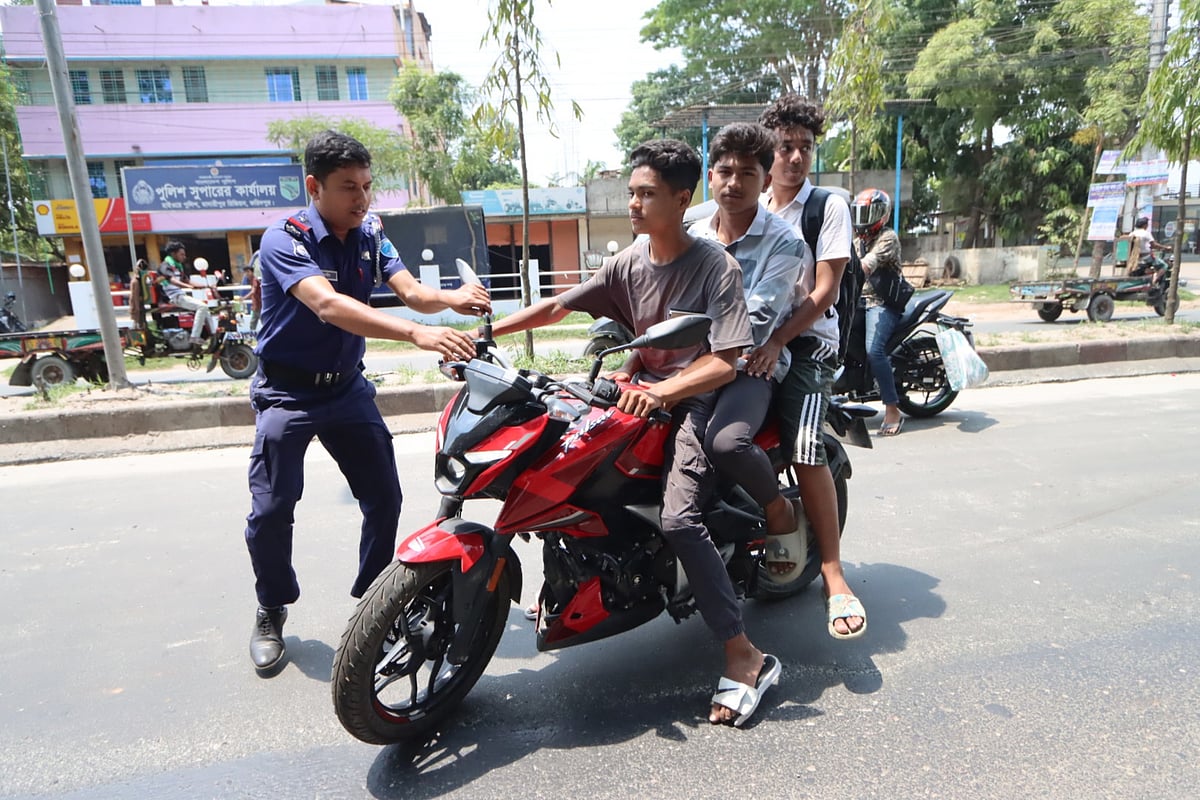 মোটরসাইকেলে দুজনের বেশি ওঠা নিষেধ। তার ওপর আবার আরোহীদের কারও মাথায় নেই হেলমেট। তাই তাঁদের বিরুদ্ধে আইনগত ব্যবস্থা নিতে মোটরসাইকেলটি আটকানোর চেষ্টা করছে পুলিশ। ব্রাহ্মণ কান্দা এলাকা, ফরিদপুর, ১৬ মে
