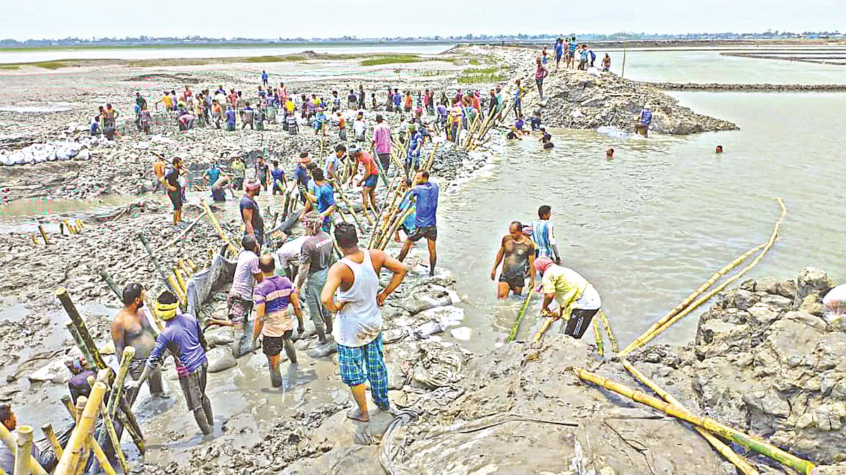 ভেঙে যাওয়া বাঁধটি স্বেচ্ছাশ্রমে মেরামতের চেষ্টা করছেন এলাকাবাসী। গতকাল খুলনার কয়রার দশালিয়া এলাকায় কপোতাক্ষ নদের পাড়ে