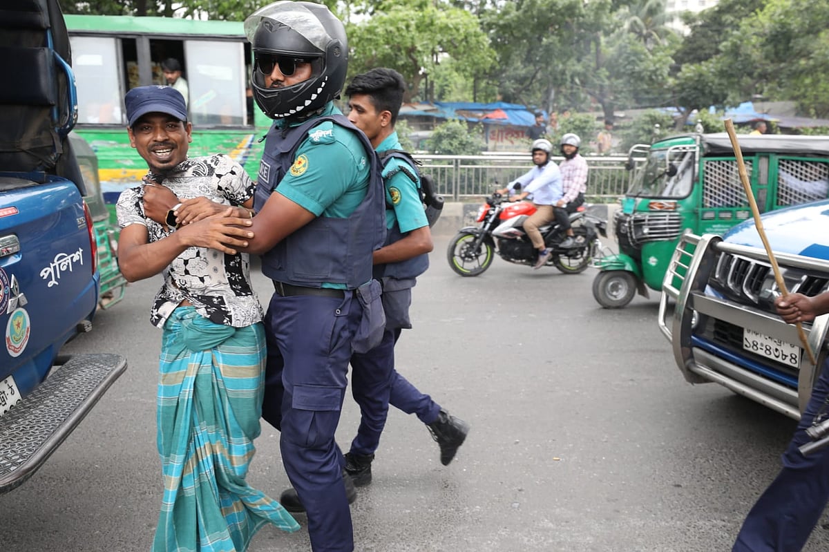 ব্যাটারিচালিত রিকশা বন্ধের প্রতিবাদে সড়কে বিক্ষোভের ঘটনায় এক ব্যক্তিকে ধরে নিয়ে যাচ্ছে পুলিশ। ঢাকা, ২০ মে