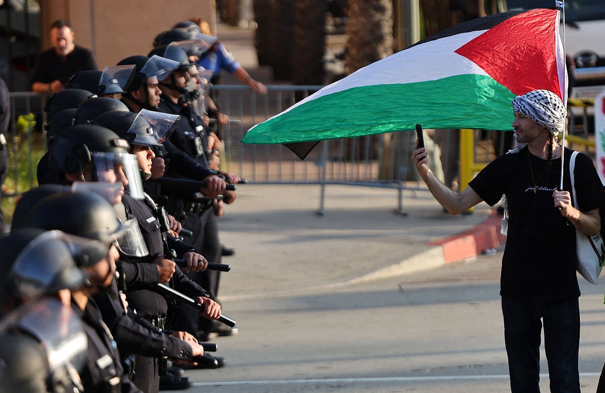 স্নাতক সমাপনী অনুষ্ঠান উপলক্ষে মোতায়েন করা হয়েছে পুলিশ। এর মধ্যেও ফিলিস্তিনের পাতাকা হাতে বিক্ষোভে অংশ নেন এক শিক্ষার্থী। ১২ মে, পোমোনা কলেজ, লস অ্যাঞ্জেলেস, ক্যালিফোর্নিয়া, যুক্তরাষ্ট্র