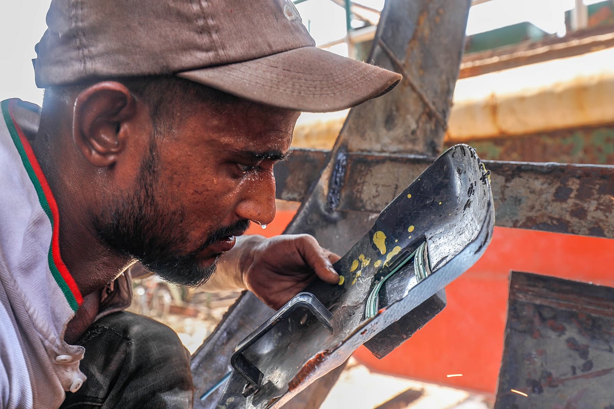 জাহাজ মেরামতের কাজ করতে গিয়ে ঘামে ভিজে গেছেন শ্রমিক। দুই নম্বর কাস্টমঘাট, খুলনা