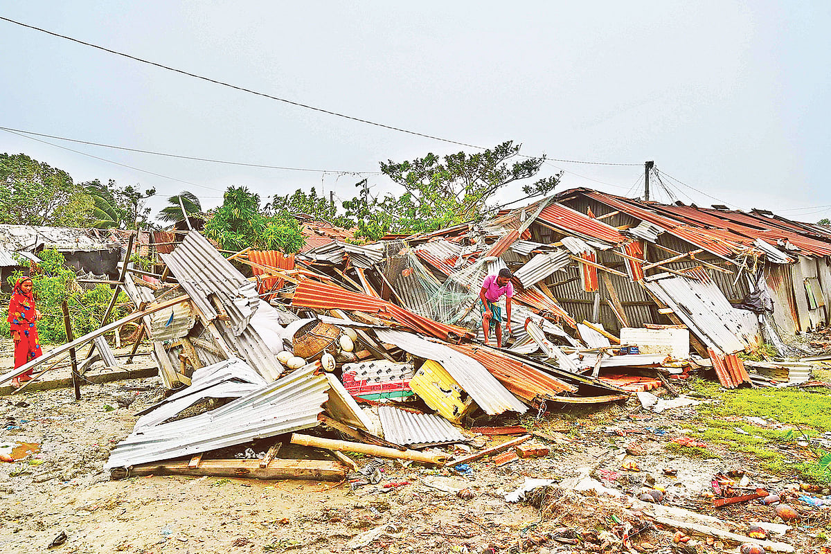 ঘূর্ণিঝড় রিমালের আঘাতে ধসে পড়েছে বসতঘর। অক্ষত জিনিসপত্র খুঁজে দেখছেন এক ব্যক্তি। গতকাল পটুয়াখালীর কুয়াকাটায়