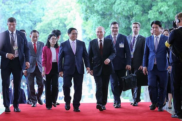 সফররত রাশিয়ার প্রেসিডেন্ট ভ্লাদিমির পুতিন (মাঝে-ডানে) ও ভিয়েতনামের প্রধানমন্ত্রী ফাম মিন চিন (পুতিনের ডানে) সহকারীদের নিয়ে একসঙ্গে হেঁটে যাচ্ছেন। গতকাল দেশটির রাজধানী হ্যানয়ের সরকারি দপ্তরের সামনে