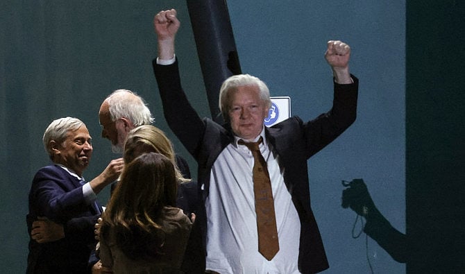 ক্যানবেরা বিমানবন্দরে দুই হাত উঁচু করে জুলিয়ান অ্যাসাঞ্জের উচ্ছ্বাস প্রকাশ। ক্যানবেরা, অস্ট্রেলিয়া, ২৬ জুন, ২০২৪