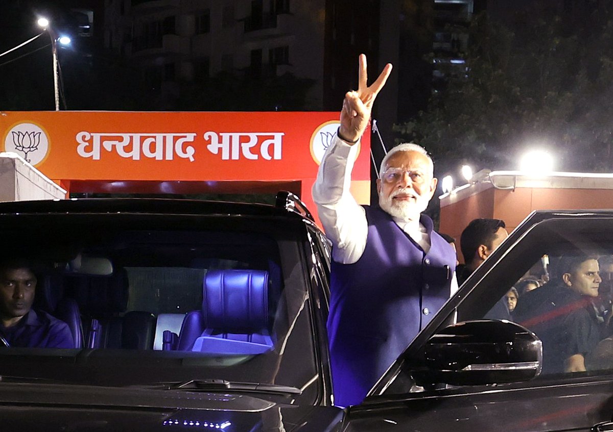 বিজেপির কেন্দ্রীয় দপ্তরের সামনে সমর্থকদের উদ্দেশ্যে বিজয় চিহ্ন দেখান নরেন্দ্র মোদি। নয়াদিল্লি, ভারত, ৪ জুন’২৪