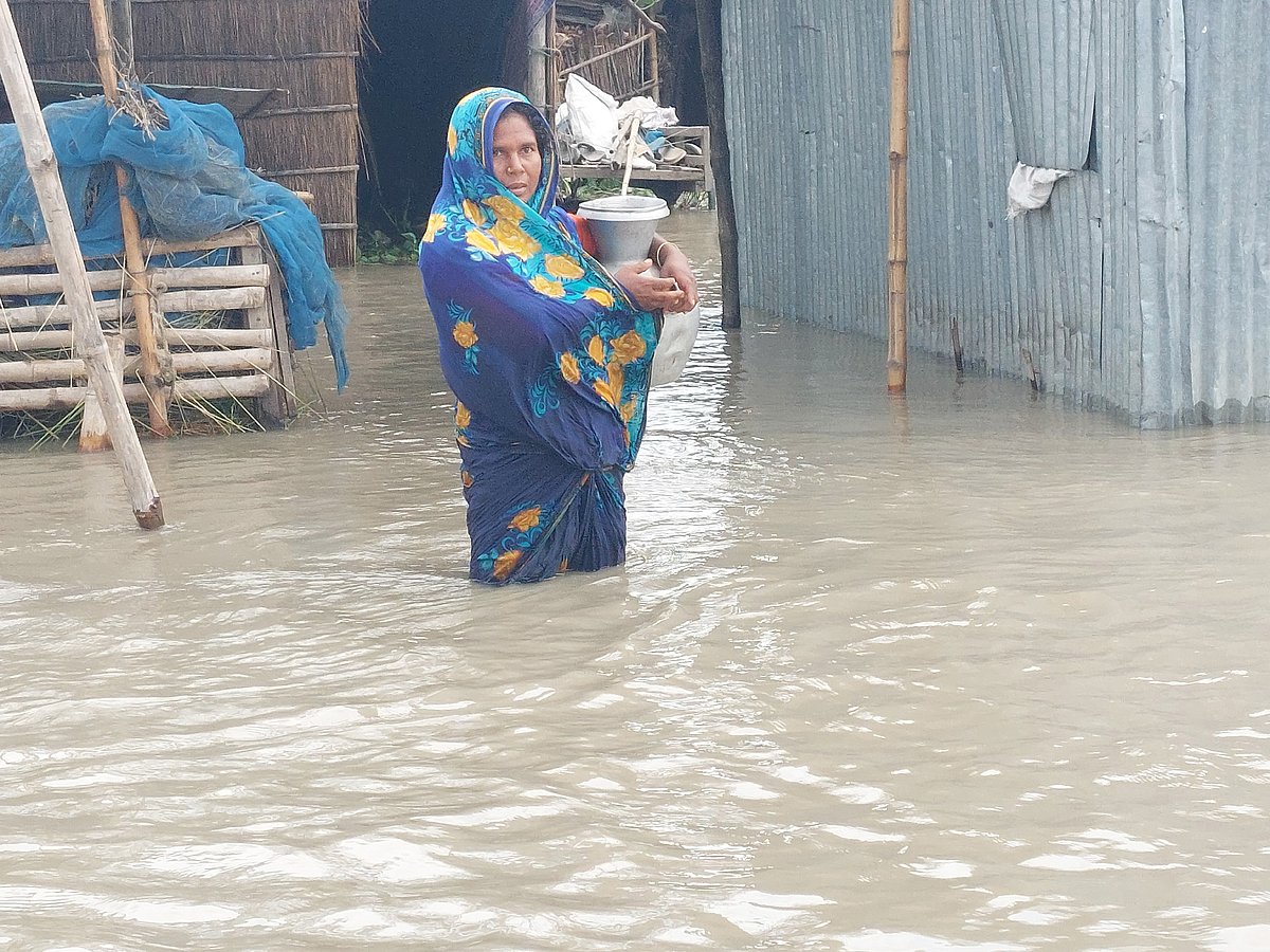 বন্যায় নলকূপ ডুবে যাওয়ায় গৃহবধূ সাহেরা বেগম কলসি নিয়ে বিশুদ্ধ পানি আনতে যাচ্ছেন। আজ দুপুরে গাইবান্ধার সুন্দরগঞ্জ উপজেলার ভাটি বোচাগাড়ি গ্রামে