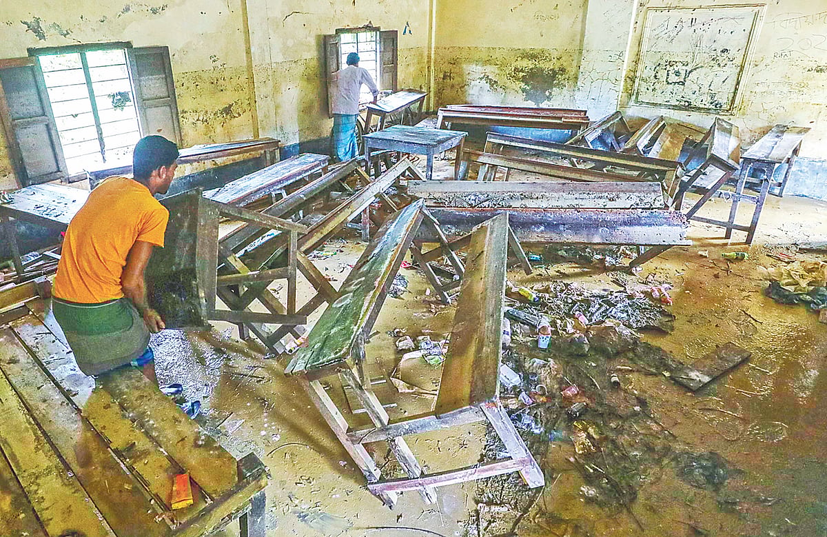 বন্যার পানিতে ব্যাপক ক্ষয়ক্ষতি হয়েছে শিক্ষাপ্রতিষ্ঠানগুলোতেও। শ্রেণিকক্ষ পরিষ্কার করছেন দুই কর্মচারী। গত সোমবার ফেনীর ফাজিলপুর ওয়ালিয়া ফাজিল মাদ্রাসায়