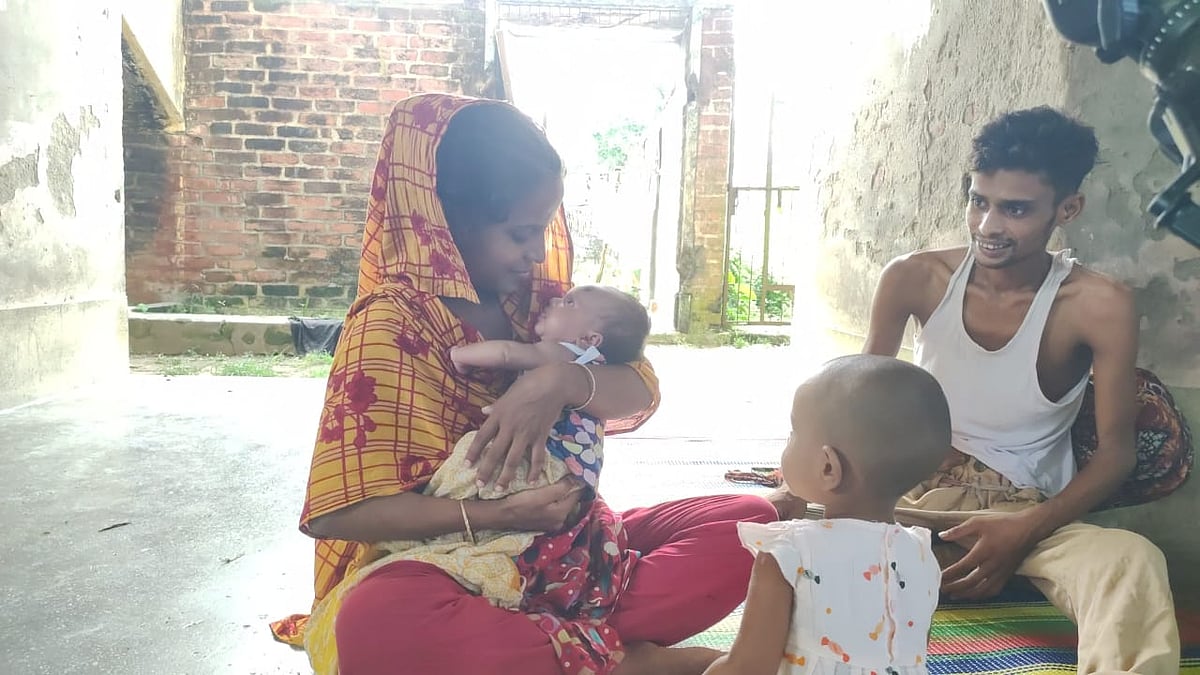 মায়ের কোলে নবজাতক। পাশে বসা বৈষম্যবিরোধী আন্দোলনে গুলিবিদ্ধ বাবা। মঙ্গলবার সকালে দিনাজপুর শহরের কাটাপাড়া এলাকায় রশিদের বাসায়