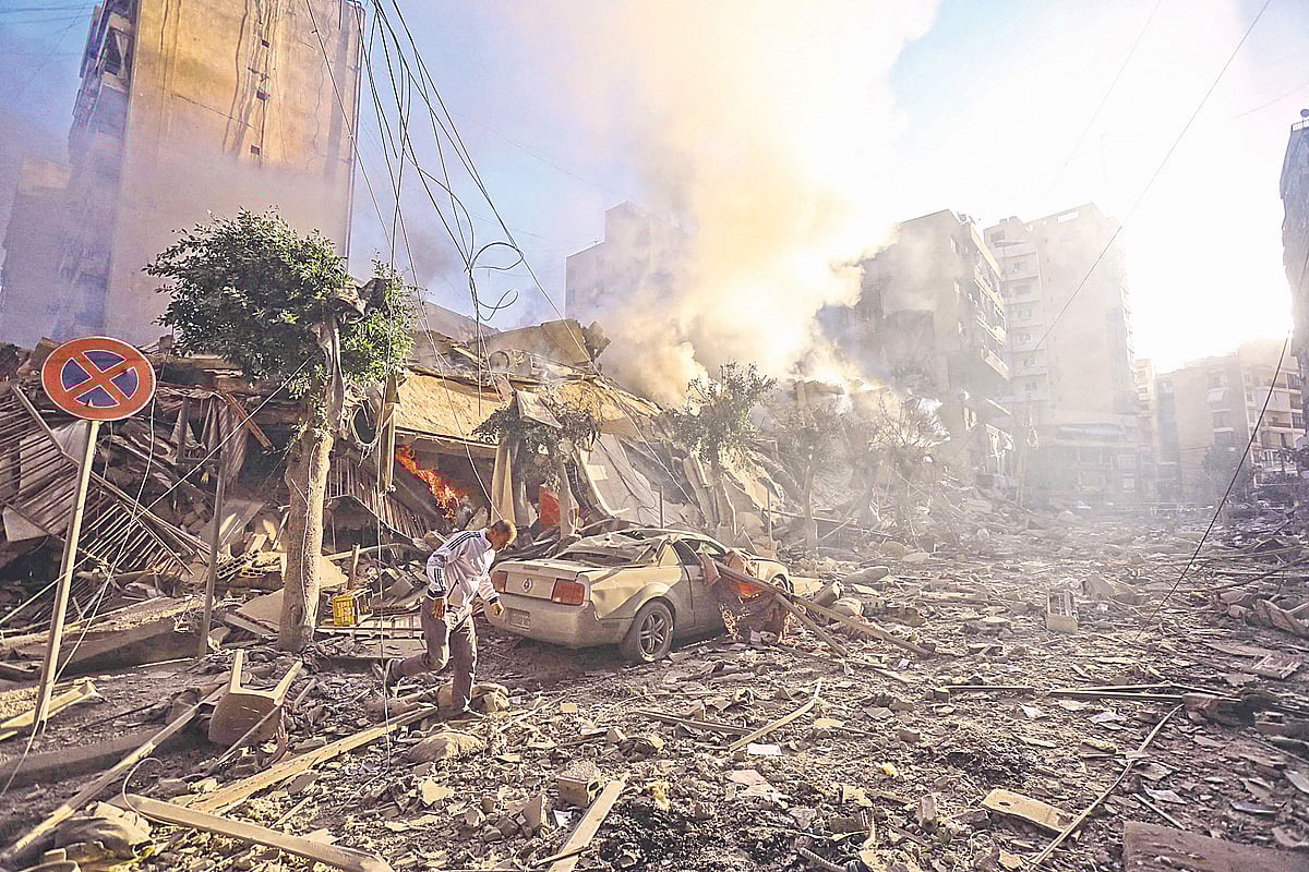 লেবাননের রাজধানী বৈরুতে ইসরায়েলি হামলায় বিধ্বস্ত ভবনের ধ্বংসস্তূপের মধ্য দিয়ে যাচ্ছেন এক ব্যক্তি। গতকাল বৈরুতের দক্ষিণাঞ্চলীয় মোয়াওয়াদ শহরতলিতে