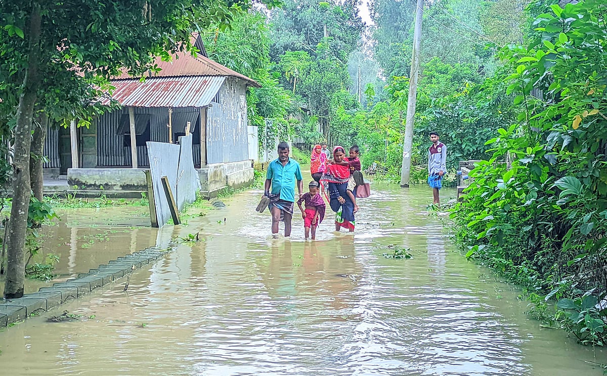 ডুবে যাওয়া সড়কের পানি মাড়িয়ে গন্তব্যে ছুটছেন স্থানীয় লোকজন। মঙ্গলবার বিকেলে কুড়িগ্রামের রৌমারী সদর উপজেলার ইজলামারী এলাকায়