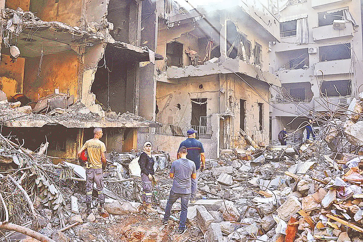 ইসরায়েলি বাহিনীর বিমান হামলায় ধ্বংসস্তূপে পরিণত হয়েছে ঘরবাড়ি। সেখানকার পরিস্থিতি দেখছেন কয়েকজন। গতকাল লেবাননের বৈরুতে