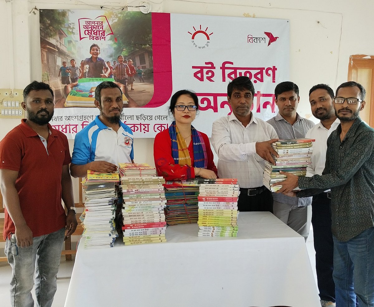 অনুষ্ঠানে একটি প্রতিষ্ঠানের প্রতিনিধির হাতে বই তুলে দেওয়া হচ্ছে। আজ শনিবার সকালে খাগড়াছড়ির স্কাউট ভবনে