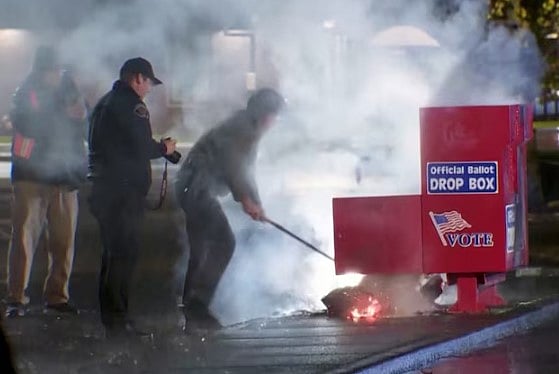 ওয়াশিংটনের ভ্যানক্যুভারে ড্রপ বাক্সের আগুন নেভানোর চেষ্টা করছেন কয়েকজন কর্মী