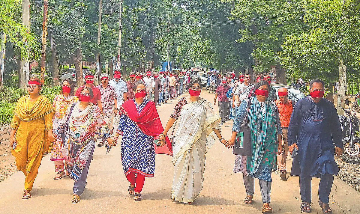 শিক্ষার্থীদের দাবির প্রতি সংহতি জানিয়ে মুখে লাল কাপড় বেঁধে ‘নিপীড়নের বিরুদ্ধে জাহাঙ্গীরনগর’–এর ব্যানারে শিক্ষকেরা। ৩০ জুলাই ২০২৪