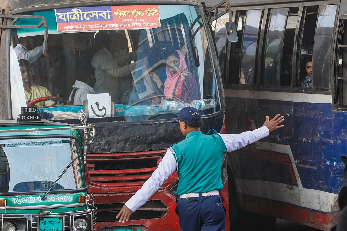 বাসের সামনে দাঁড়িয়ে ট্রাফিক নিয়ন্ত্রণ