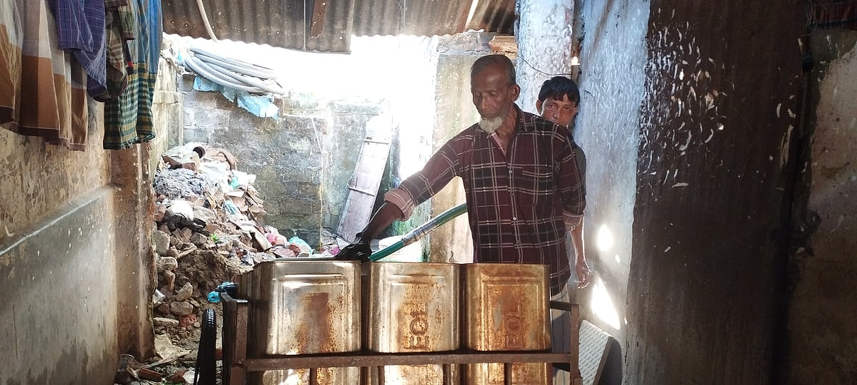 সিলেট নগরের বারুতখানা এলাকায় বিক্রির জন্য ঠেলাগাড়িতে থাকা টিনে পানি ভরছেন সাইফুল ইসলাম