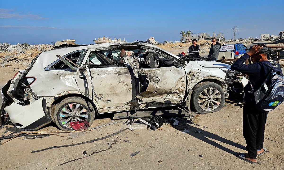 ইসরায়েলি হামলায় ক্ষতিগ্রস্ত গাড়ি দেখছেন কয়েকজন ফিলিস্তিনি। খান ইউনিস, গাজা
