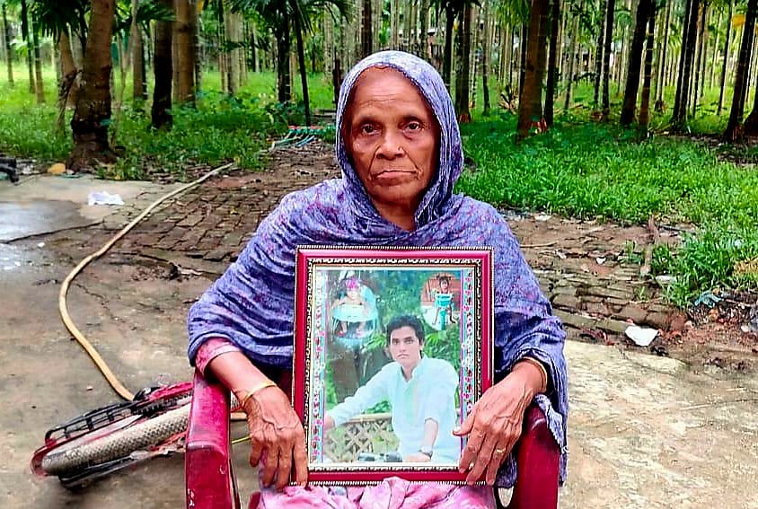 নিখোঁজ মো. আবদুল্লাহর ছবি হাতে মা রহিমা খাতুন। সম্প্রতি কক্সবাজারের টেকনাফ সদরের জাহালিয়াপাড়ায়