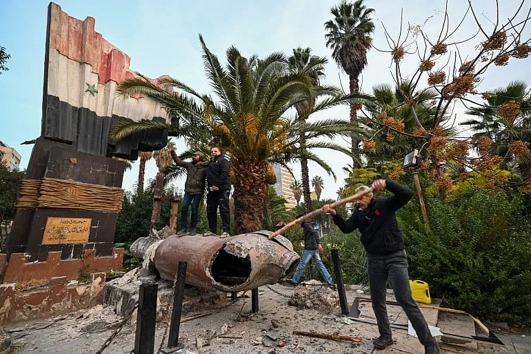 দামেস্কে সিরিয়ার সাবেক প্রেসিডেন্ট হাফিজ আল-আসাদের একটি ভাস্কর্য ভেঙে ফেলা হচ্ছে। ৮ ডিসেম্বর ২০২৪