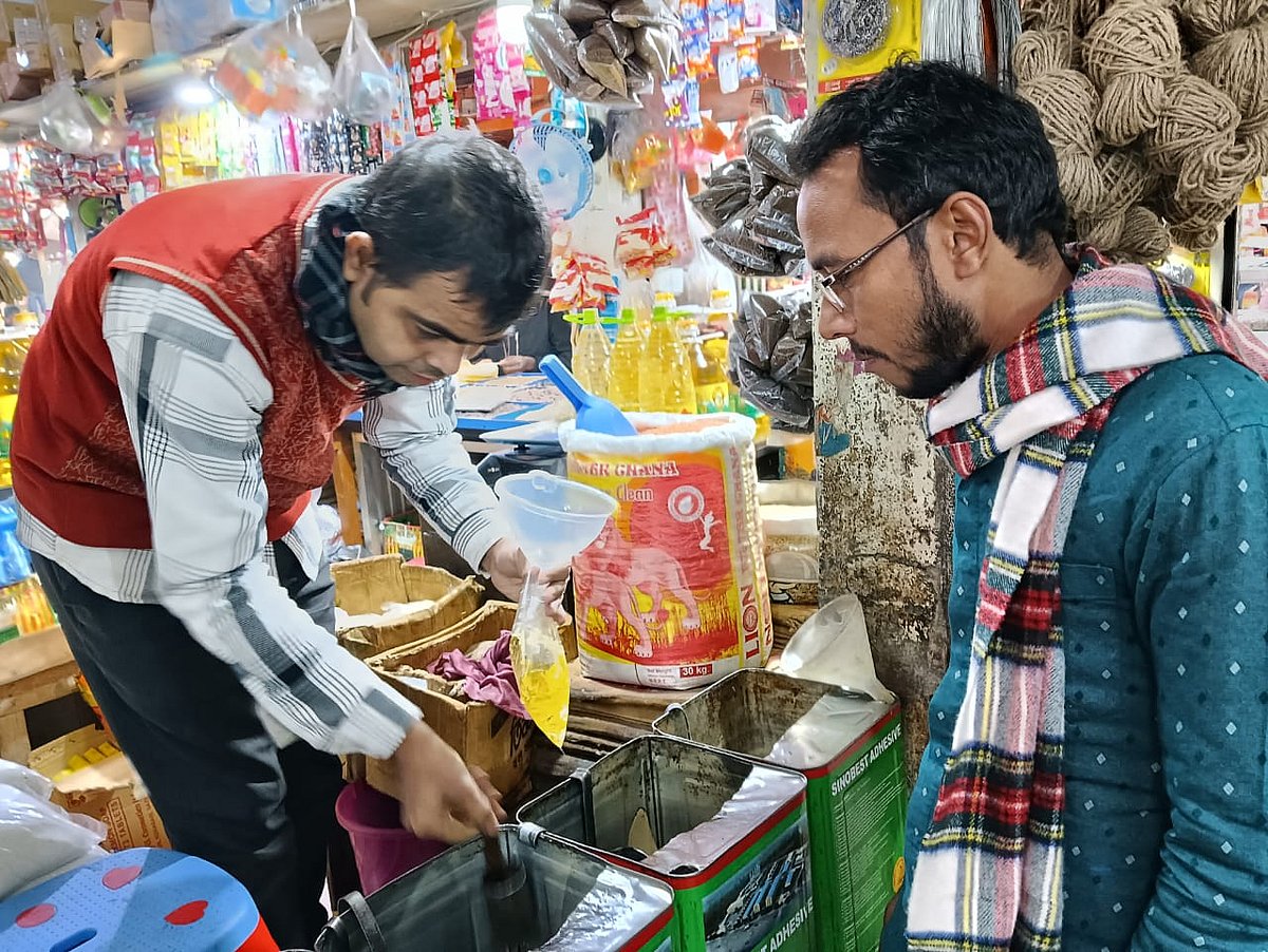 খোলা সয়াবিন তেল কিনছেন এক ব্যক্তি। গতকাল বুধবার বিকেলে রংপুরের তারাগঞ্জ বাজারে