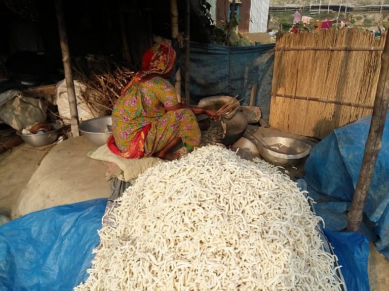 রোদে শুকানোর পর ঝুরি পিঠা গরম বালিতে ভেজে নিচ্ছেন এক নারী। সম্প্রতি সিরাজগঞ্জের শাহজাদপুর উপজেলার হাট পাঁচিল গ্রামে