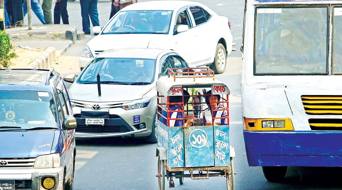 বিপরীত দিক থেকে ছুটে আসছে যানবাহন। ডানে গাড়ি, বাঁয়েও গাড়ি। সেসবের তোয়াক্কা না করেই শিশুদের নিয়ে ছুটে চলেছেন ভ্যানচালক।