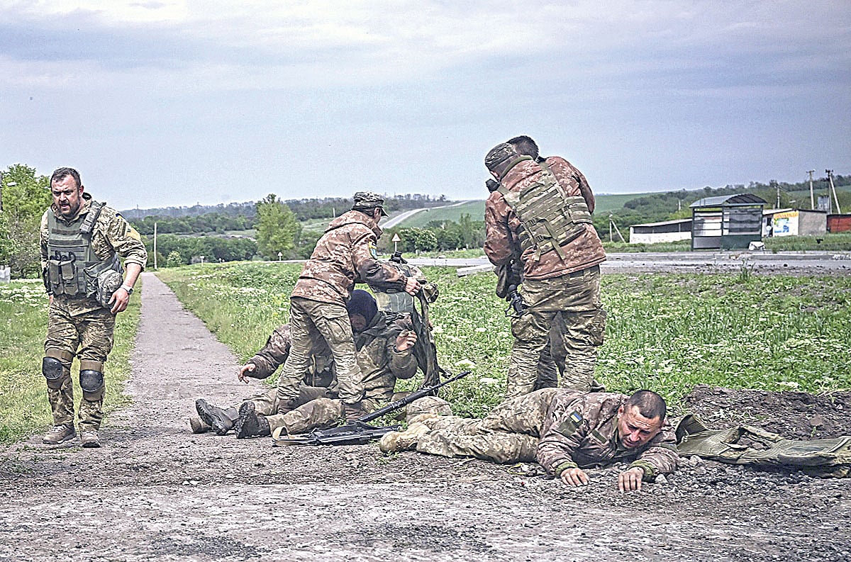 আহত এক সহকর্মীকে উদ্ধার করে নিয়ে যাচ্ছেন ইউক্রেনীয় সেনারা