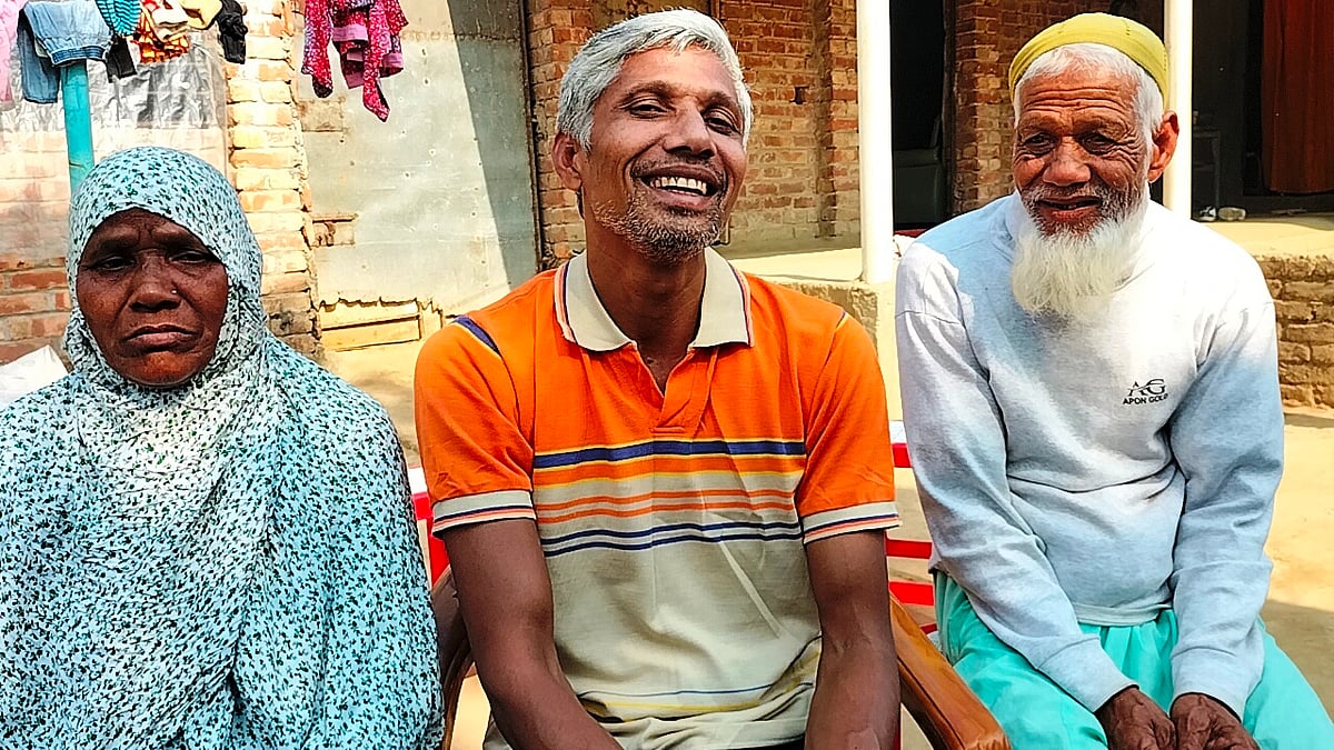 মা-বাবার মাঝখানে বেঞ্চে বসে আছেন সাদিকুল ইসলাম। বৃহস্পতিবার সকালে দিনাজপুরের বীরগঞ্জ উপজেলার ভোগনগর ইউনিয়নের দলুয়া গ্রামে