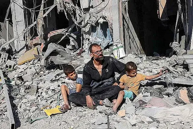 ইসরায়েলের নির্বিচার হামলায় পরিবারের অনেক সদস্যকেই হারিয়েছেন এই ফিলিস্তিনি। বেঁচে থাকা দুই সন্তানকে নিয়ে বাড়ির ধ্বংসস্তূপের নিচে এসে নিয়েছেন আশ্রয়। ১২ অক্টোবর ২০২৪, রাফ, গাজা, ফিলিস্তিন